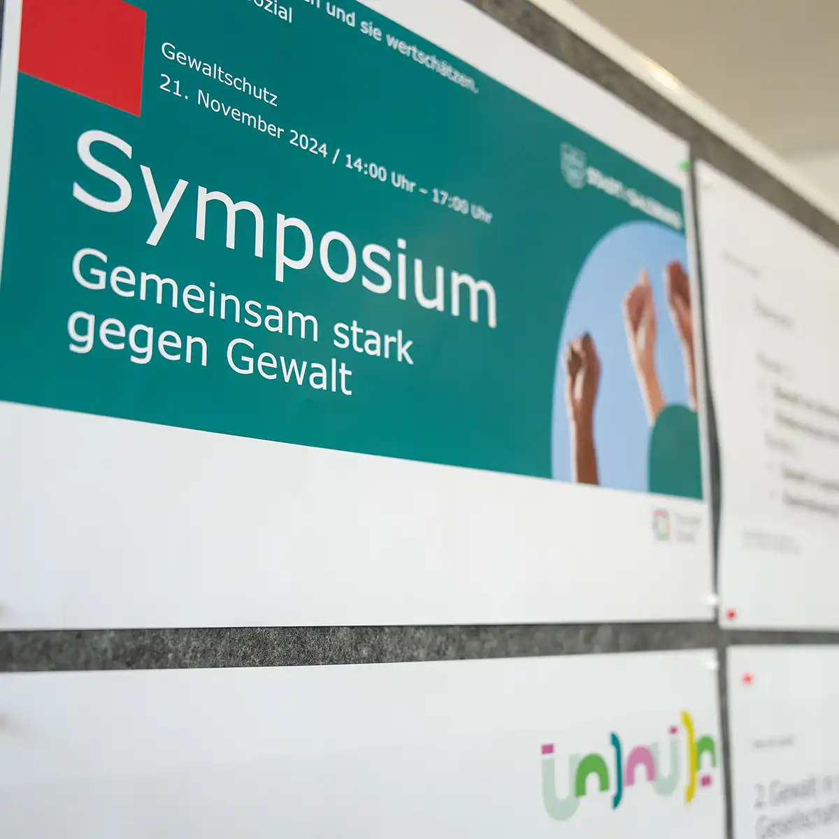 Ein Schild mit der Aufschrift Symposium wird seitlich gezeigt