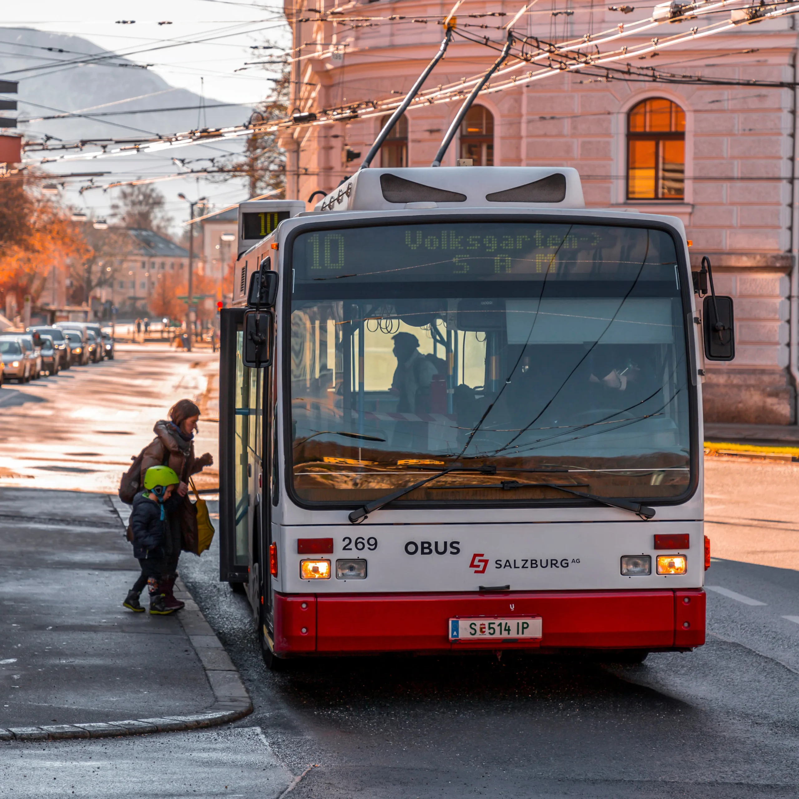 Mutter und Kind steigen in einen öffentlichen Verkehrsbus Richtung Volksgarten ein