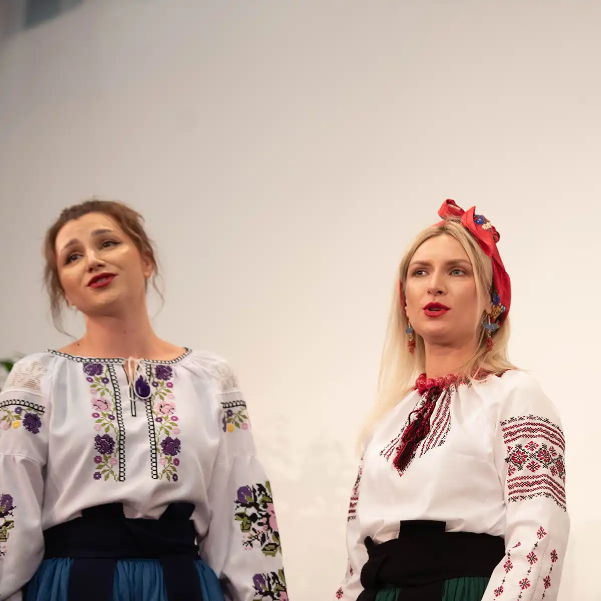 Zwei Damen mit traditioneller Kleidung führen ein Theaterstück auf