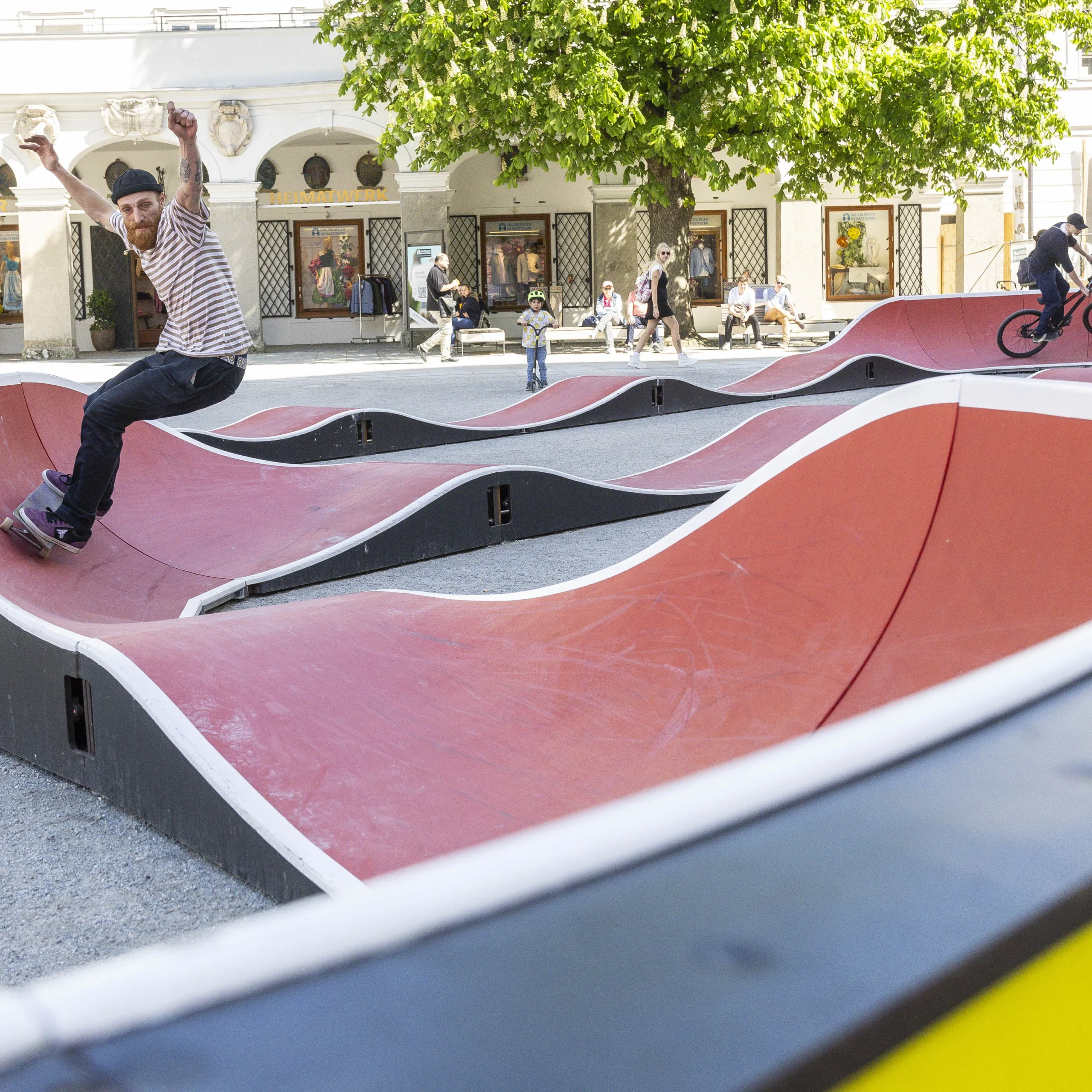 Skater mit Mütze und Radfahrer mit Kappe fahren durch einen Skaterpark