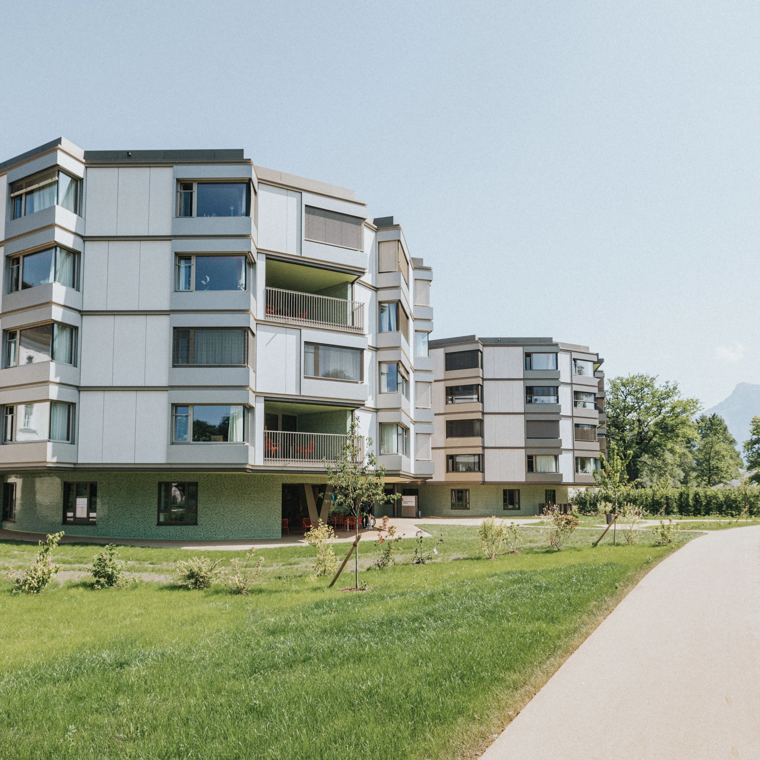 Zwei Wohngebäude im Grünen mit Blick auf die Berge und einem eigenen asphaltierten Weg