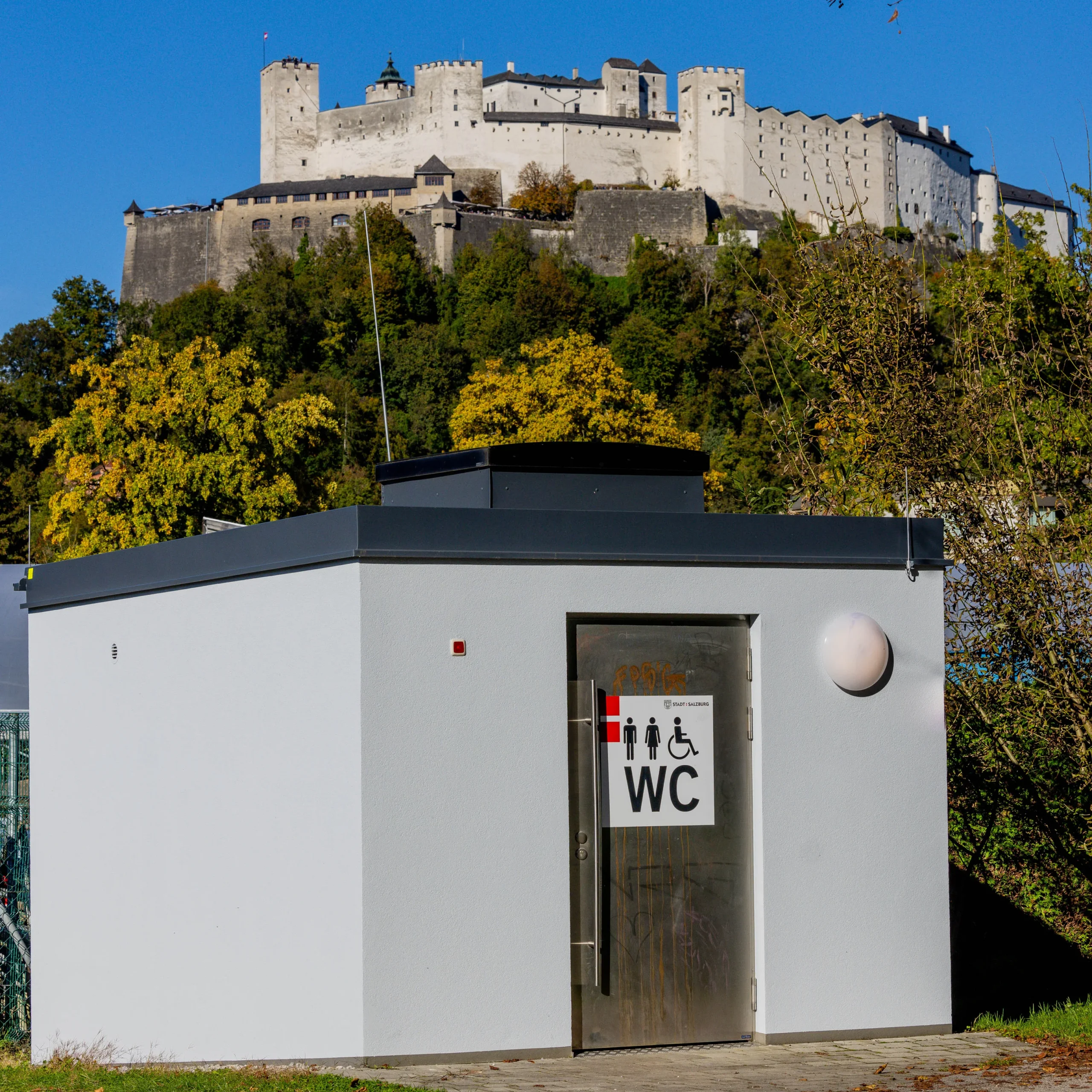 Oeffentliche Toilette mitten im grünen, die Festung erhöht im Hintergrund