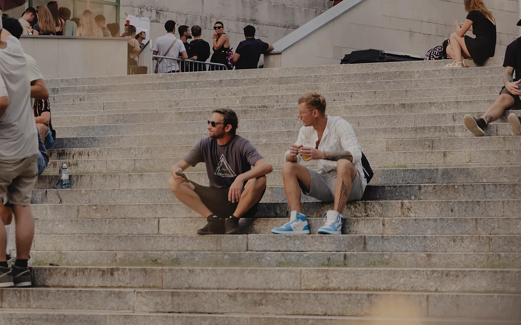Hintergrundbild mit Personen auf einer Steintreppe im Freien